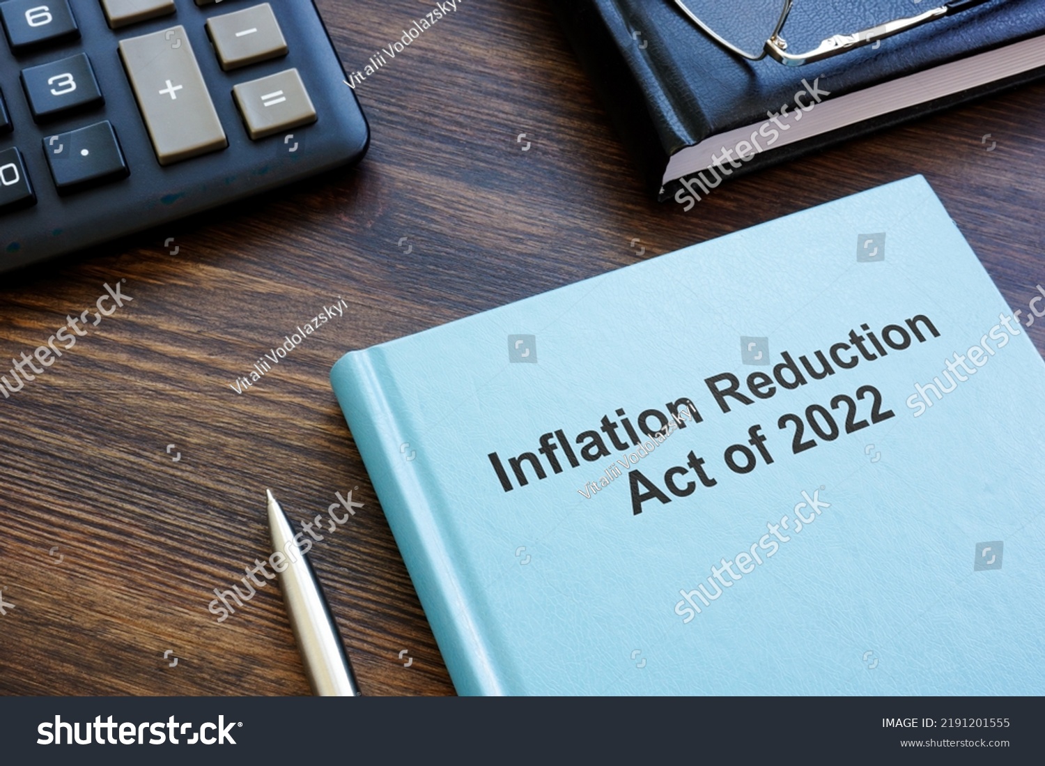 Blue book with The Inflation Reduction Act of 2022 near calculator and notebook. #2191201555