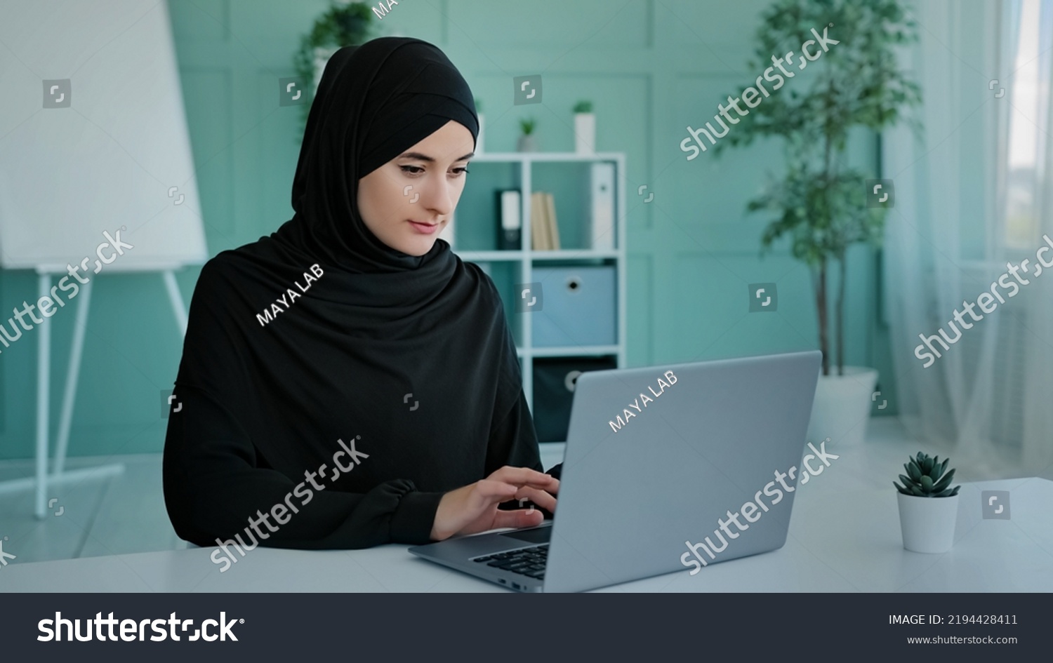 Busy Islam businesswoman in black hijab freelancer Islamic Arabian girl student worker Muslim woman female with laptop working e-learning typing online chat e-commerce app web browsing in network #2194428411