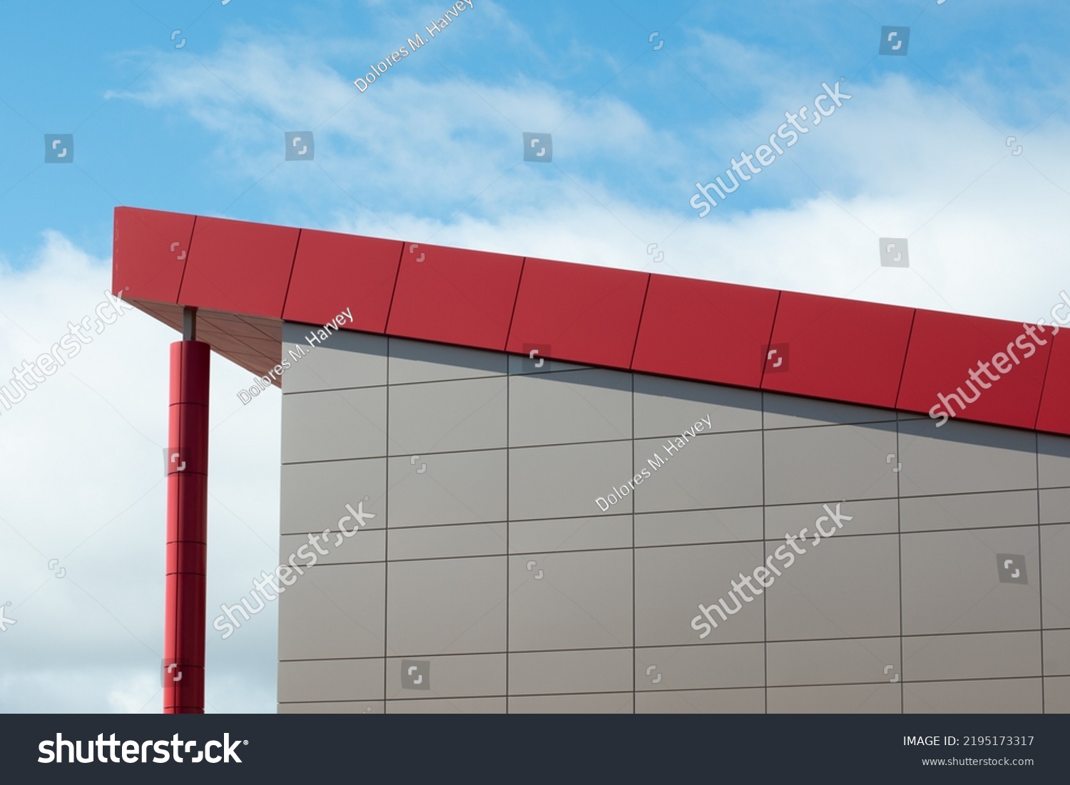 The exterior wall of a contemporary commercial style building with aluminum metal composite panels and glass windows. The futuristic building has engineered diagonal cladding steel frame panels. #2195173317