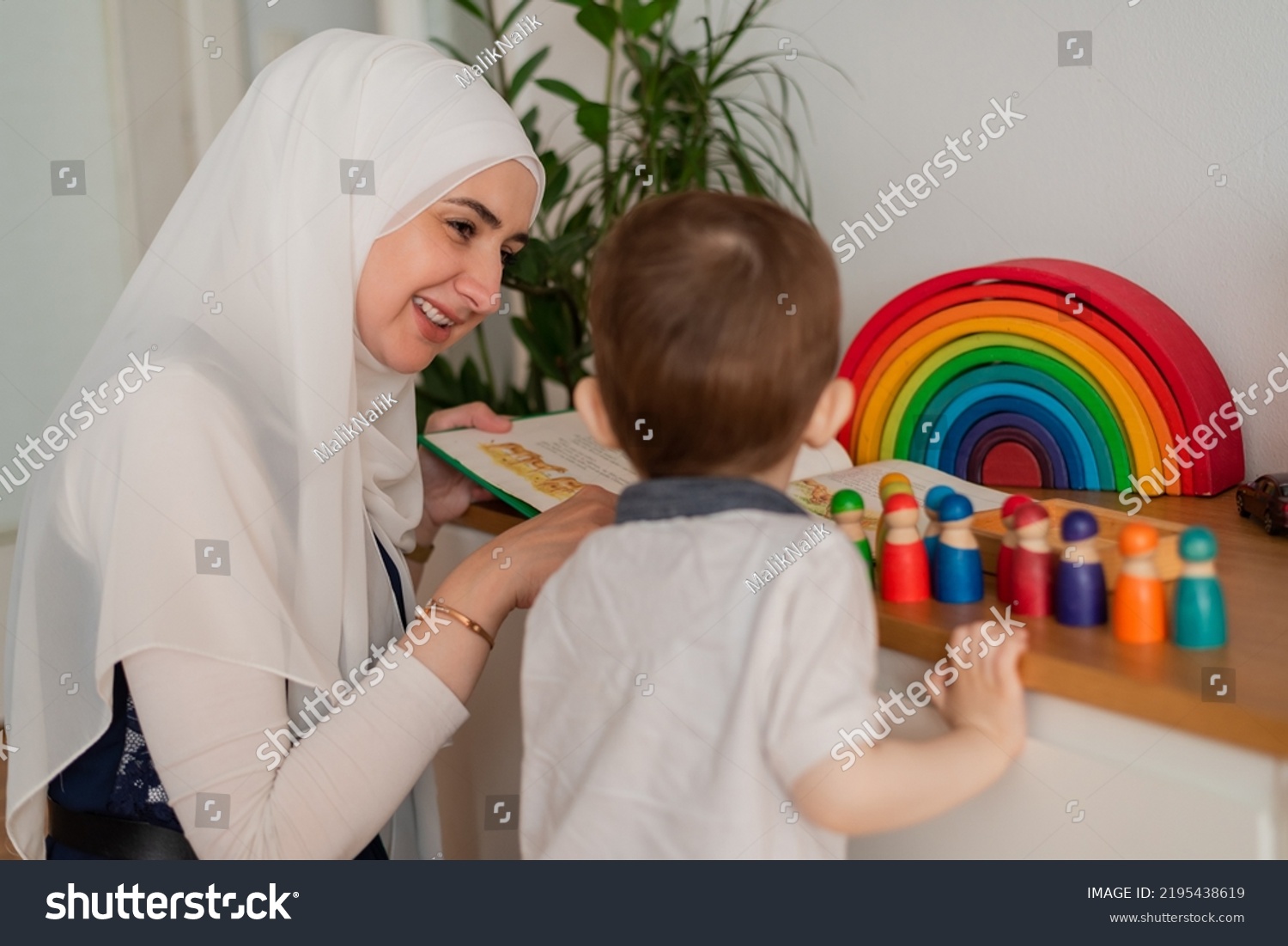 A Musllim teacher and preschool child playing together with colorful toys in the Montessori school classroom or kindergarten. #2195438619