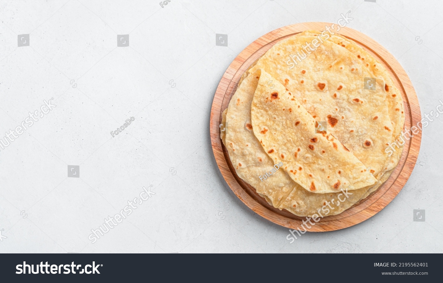 Indian chapati tortillas on a wooden board on a gray background. Traditional Indian food. Top view, copy space #2195562401