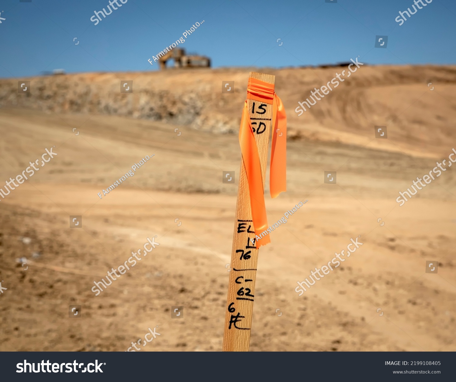 Construction grading stake with construction equipment in background #2199108405
