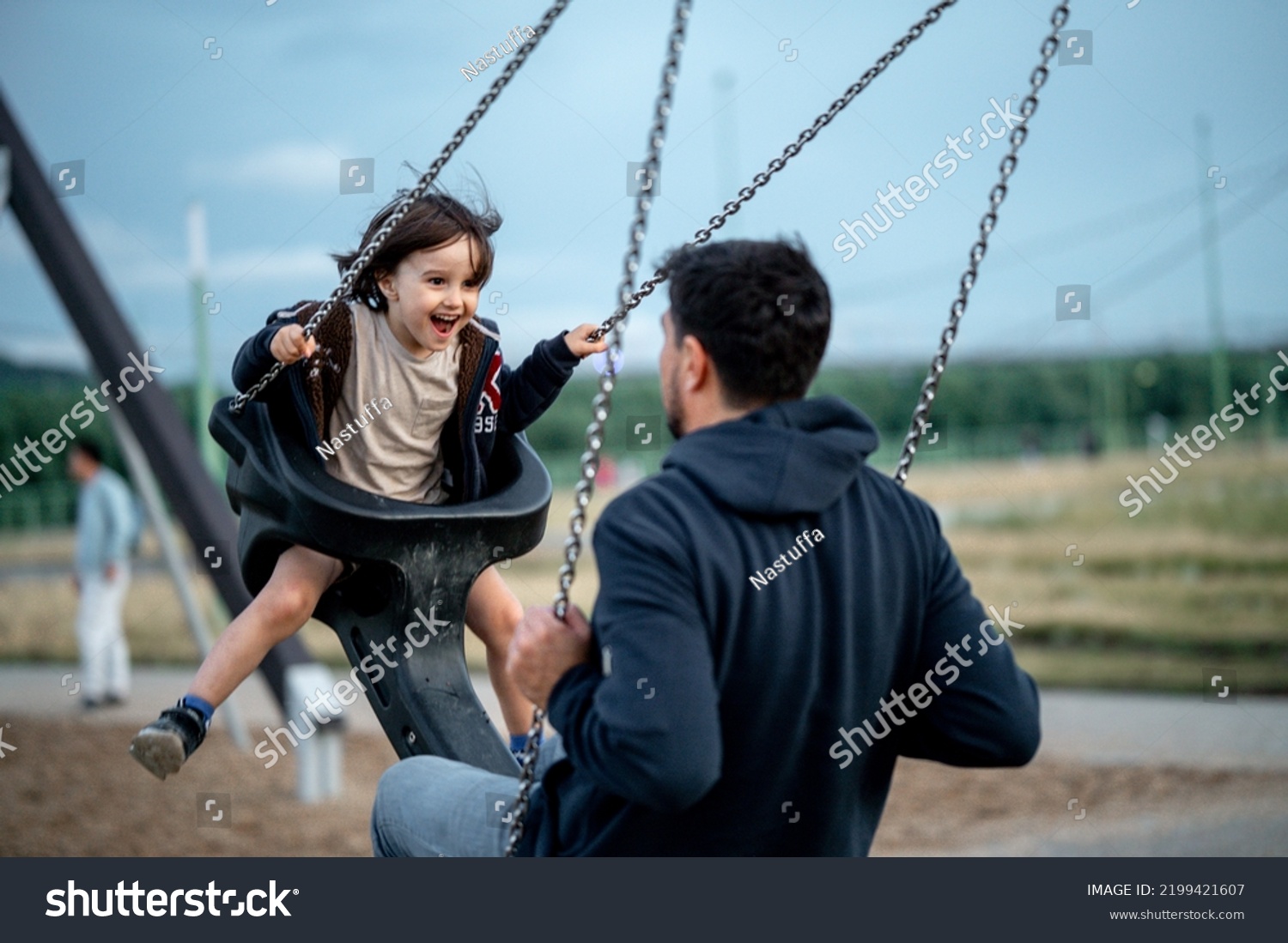 Dad and son swing on a swing. Happy family. The father spends time with the children, the father walks with the child in the summer in the park #2199421607