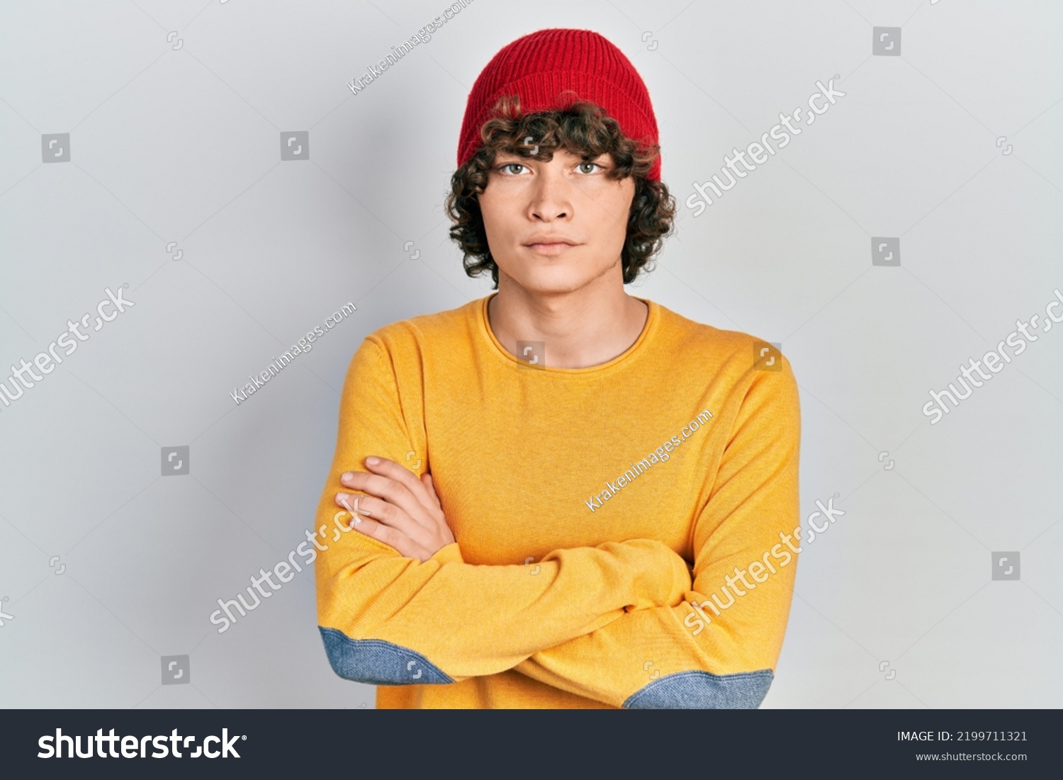Handsome young man wearing wool hat skeptic and nervous, disapproving expression on face with crossed arms. negative person.  #2199711321
