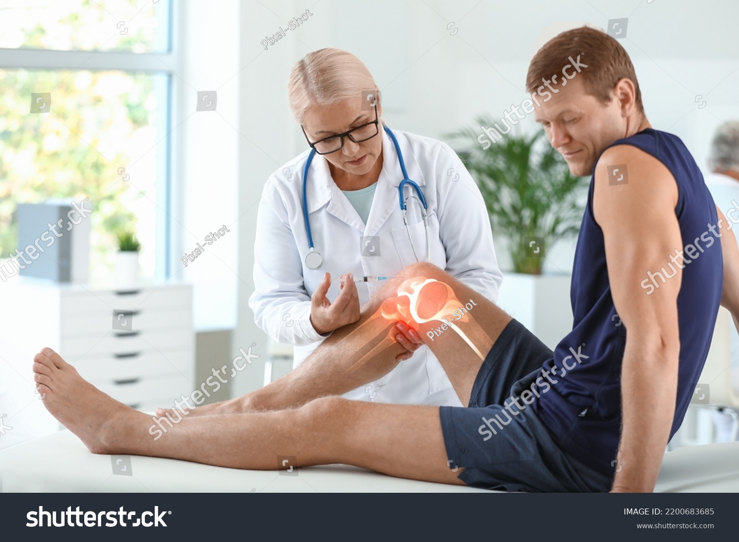 Mature doctor giving sporty man with joint pain injection in clinic #2200683685