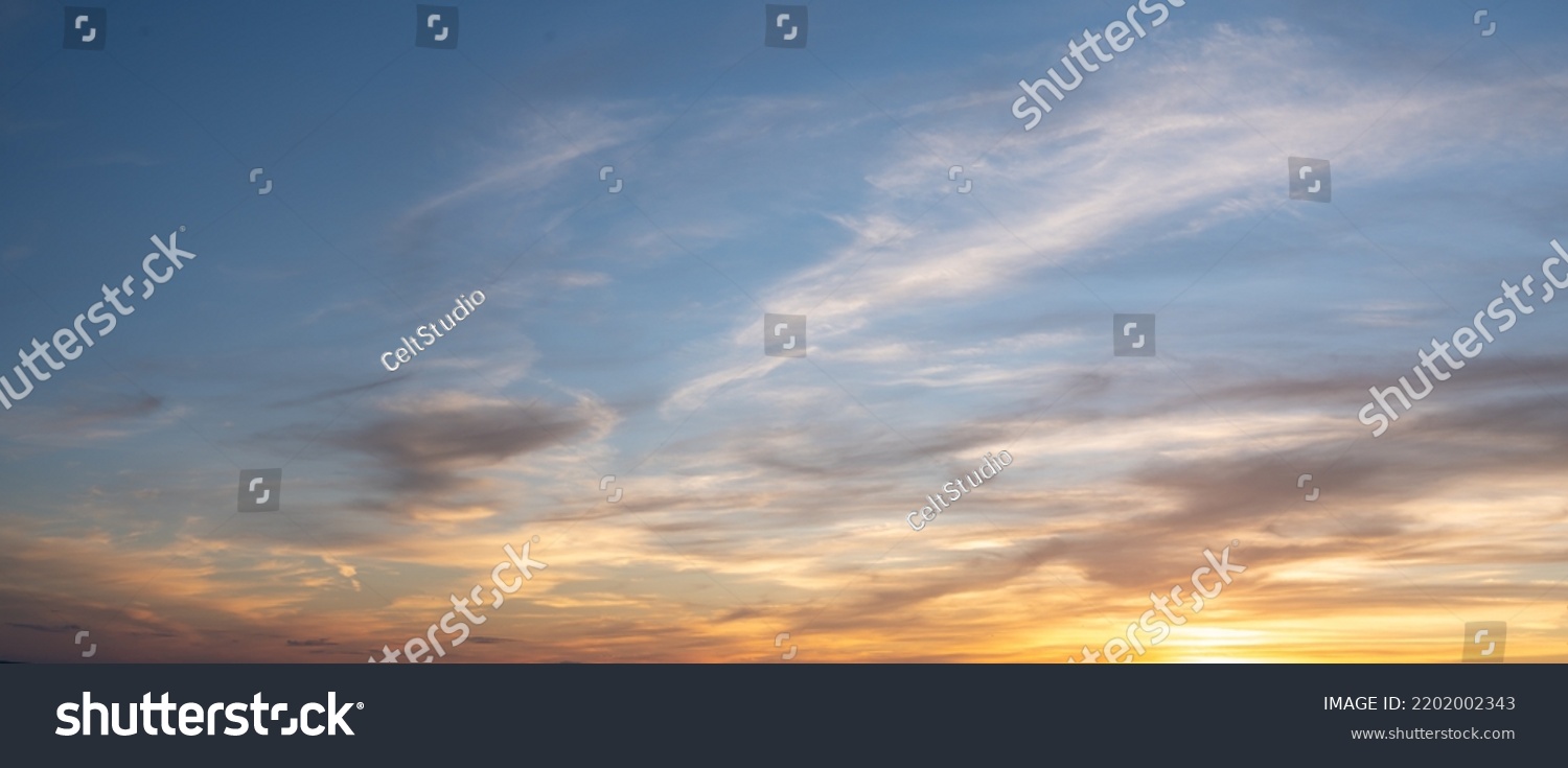Panoramic beautiful colorful golden hour twilight sky. Beautiful cloud and sky nature background in magic hour. Amazing colorful sky and dramatic sunset evening sky. #2202002343