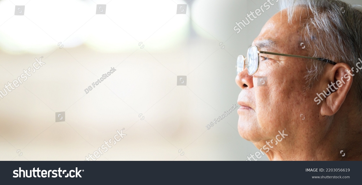 Close up on senior Asian elder man living lonely and looking outside the window. #2203056619