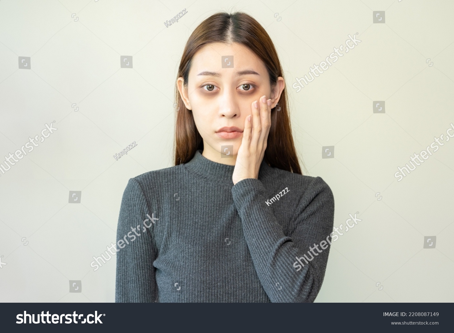 Bored, insomnia asian young woman, girl looking at camera, hand touching under eyes with problem of black circles or panda puffy, swollen and wrinkle on face. Sleepless, sleepy healthcare person. #2208087149