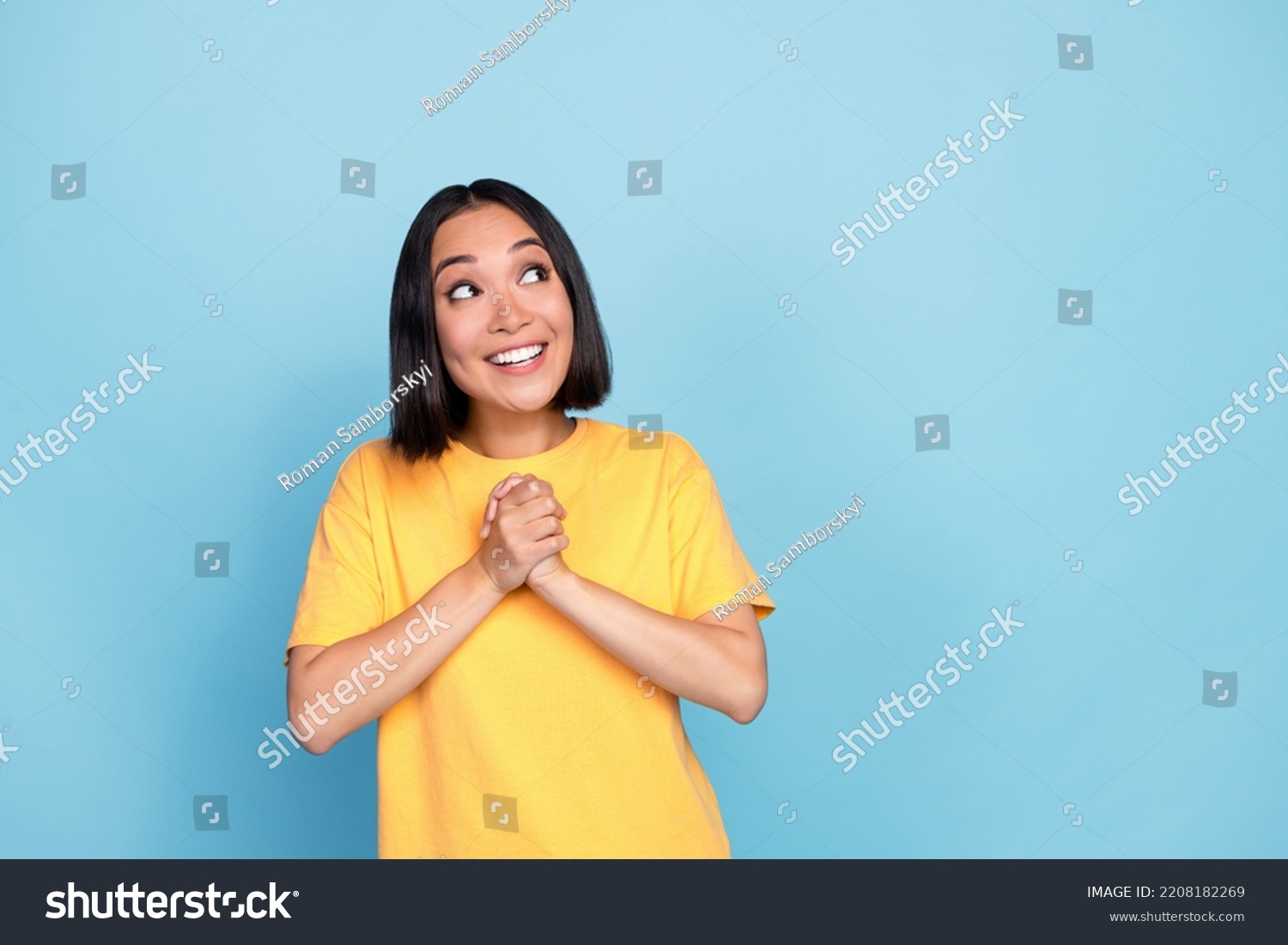Photo portrait of cute young girl korean hold hands together look copyspace dressed stylish yellow look isolated on blue color background #2208182269