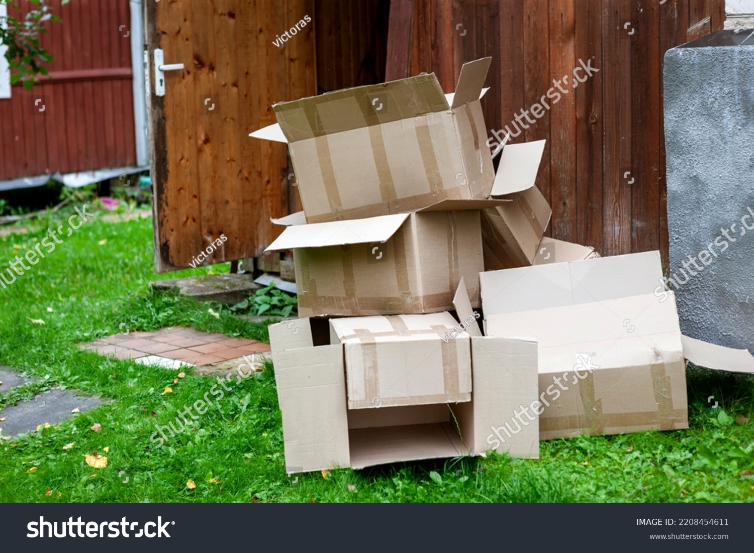 a pile of discarded empty cardboard boxes outside a house, outdoor shot #2208454611
