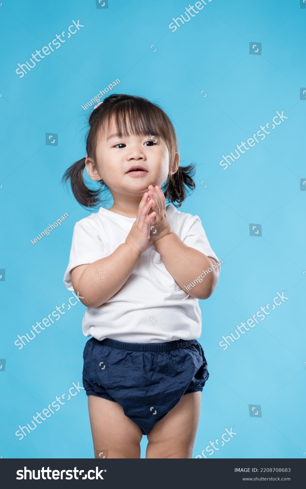 Little girl clap over blue background #2208708683