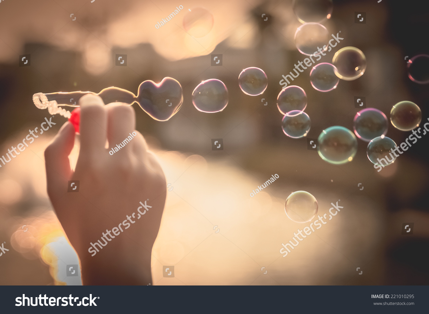  My Heart Bubbles at the sky, sunset,Love in the summer sun with bubble blower,romantic inflating colorful soap bubbles in park #221010295