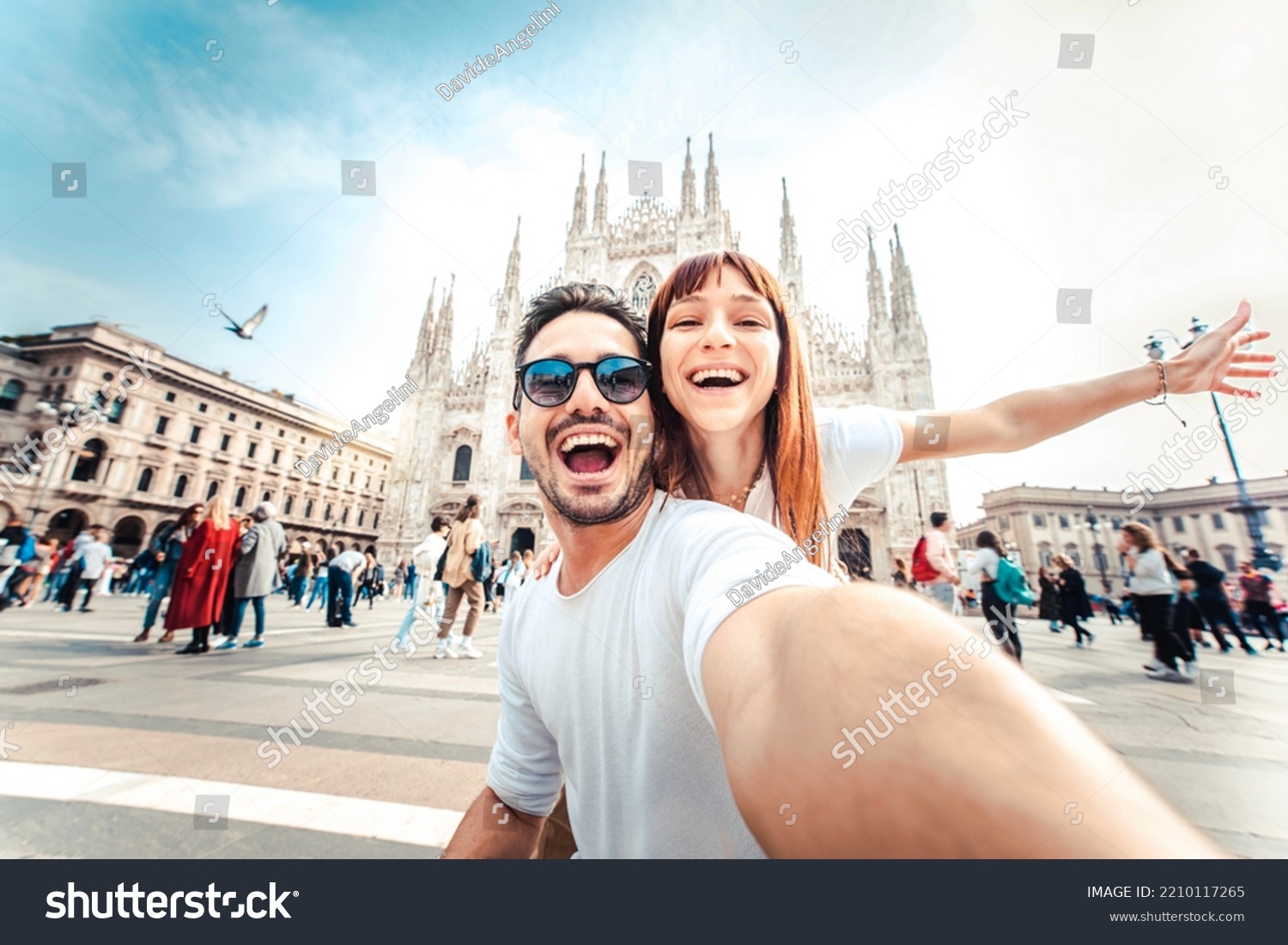 Happy couple taking selfie in front of Duomo cathedral in Milan, Lombardia - Two tourists having fun on romantic summer vacation in Italy - Holidays and traveling lifestyle concept #2210117265