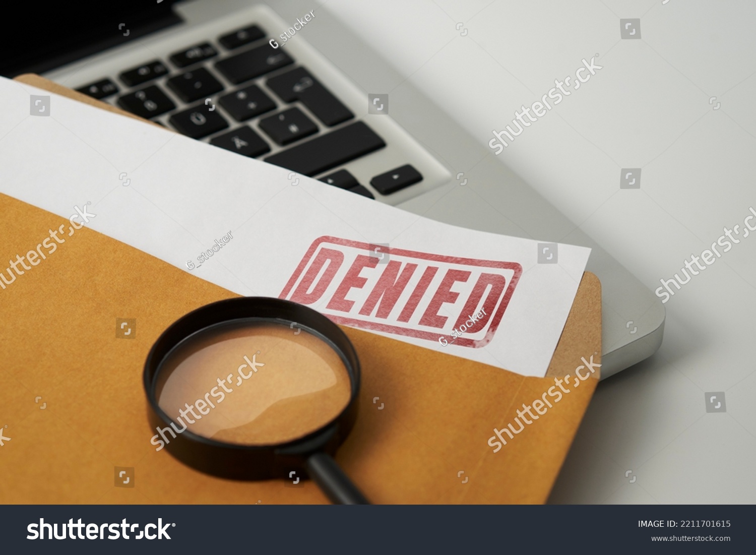 Document with denied stamp and magnifying glasses put on the laptop on wooden table, #2211701615