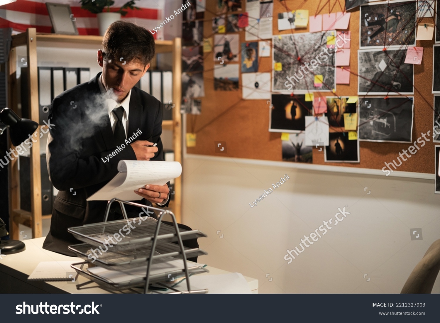 Detective working at desk in his office, smoking cigarette and thinking of investigation case #2212327903