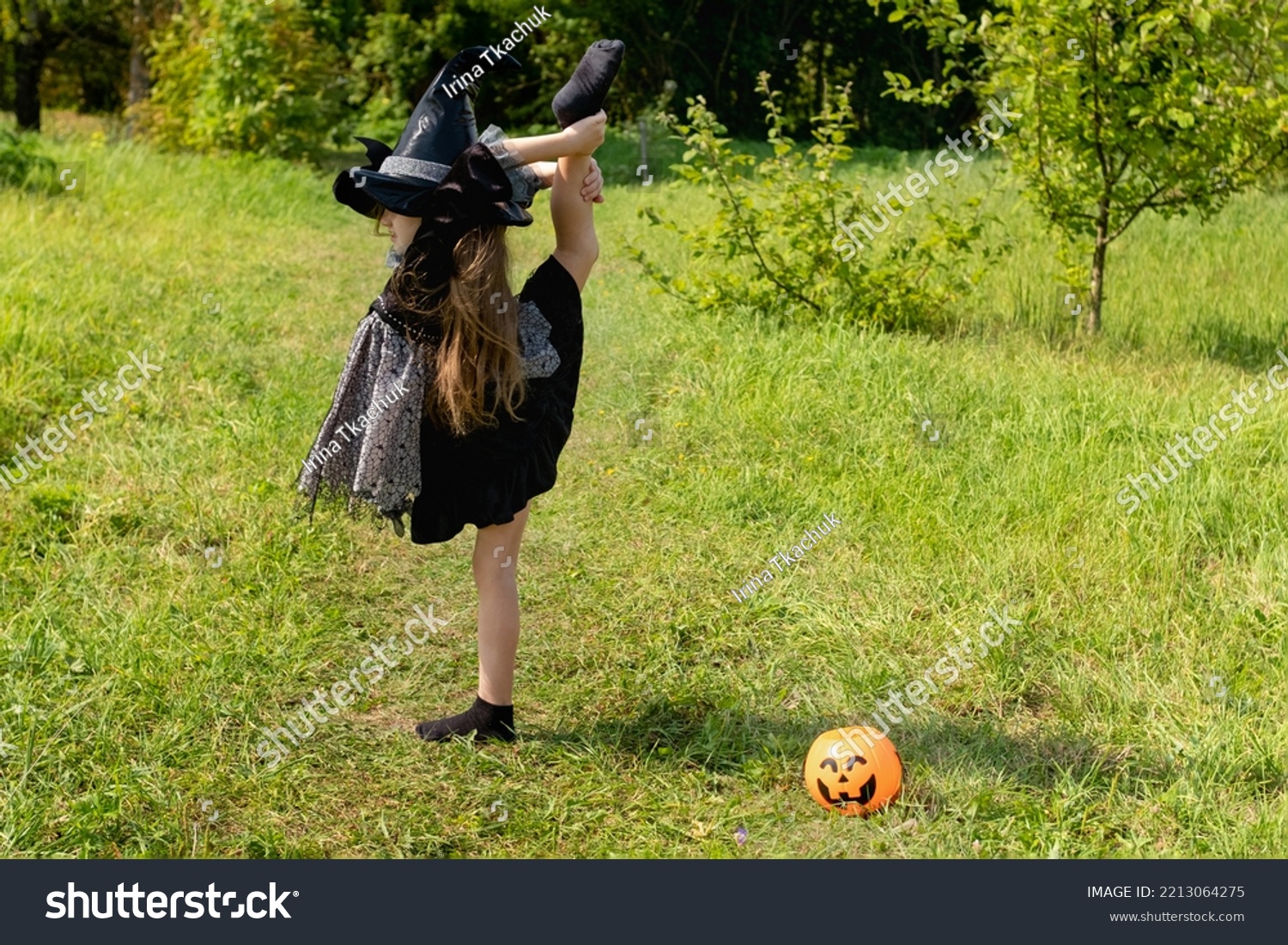 Halloween girl going to collect candy. Trick-or-treating. Guising. Jack-o-lantern. Child in carnival costume witch outdoors. Celebrate halloween. Girl in forest smiling and holding basket of sweets #2213064275
