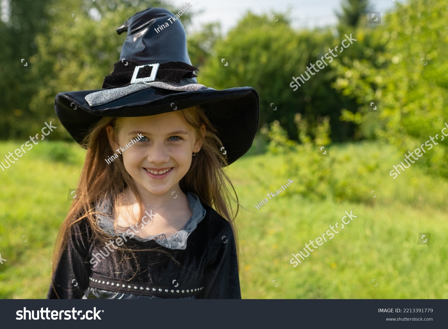 Halloween girl going to collect candy. Trick-or-treating. Guising. Jack-o-lantern. Child in carnival costume witch outdoors. Celebrate halloween. Girl in forest smiling and holding basket of sweets #2213391779