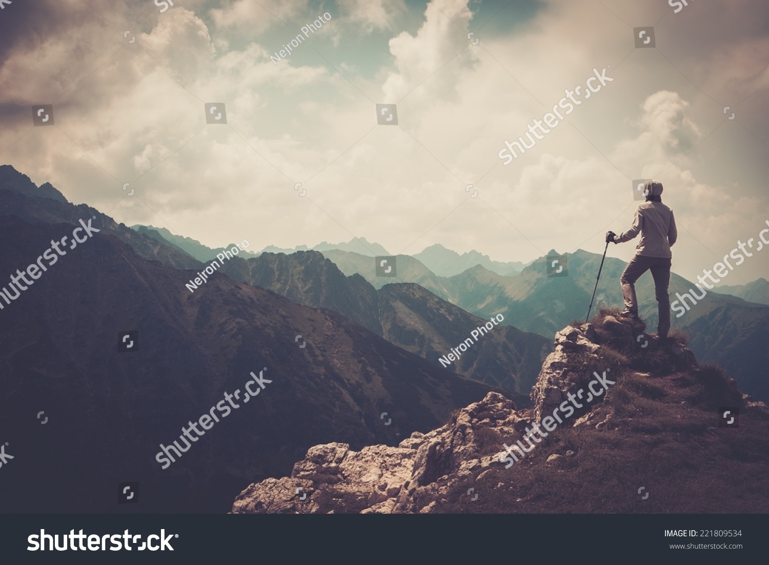 Woman hiker on a top of a mountain  #221809534