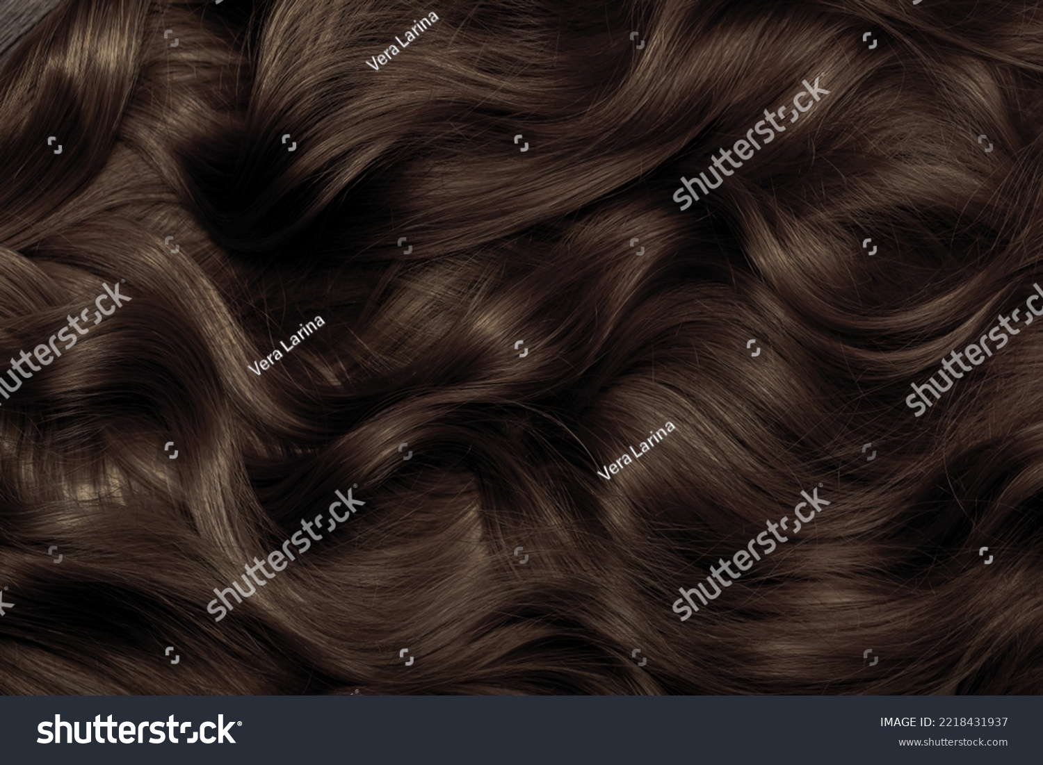 Brown hair close-up as a background. Women's long brown hair. Beautifully styled wavy shiny curls. Hair coloring. Hairdressing procedures, extension. #2218431937