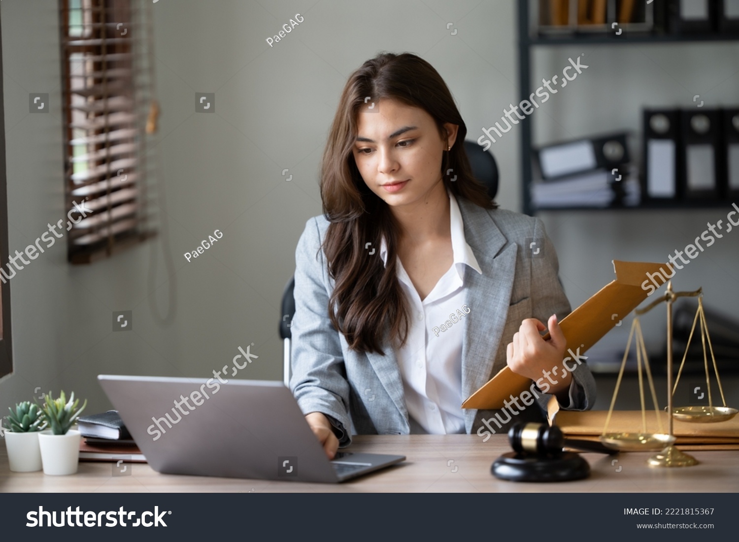 Lawyer office. Statue of Justice with scales and lawyer working on a laptop. Legal law, advice and justice concept. #2221815367