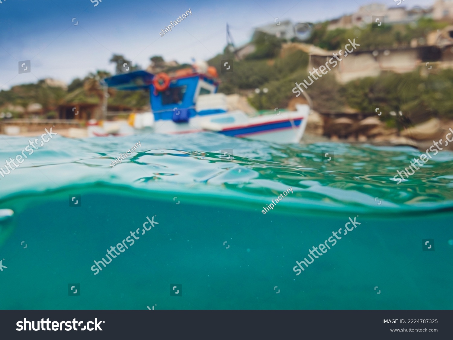 Surface level of boat moored at harbor and waves moving in blue sea against mountain #2224787325