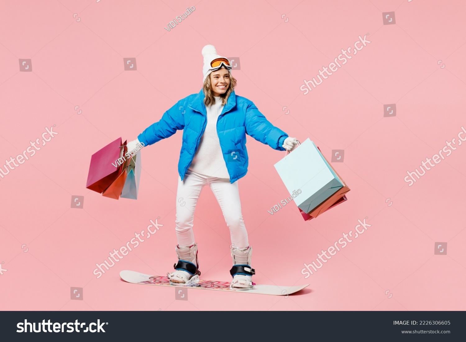 Snowboarder fun woman wear blue suit goggles mask hat ski jacket hold shopping package bags isolated on plain pink background Winter extreme sport hobby trip relax, Black Friday sale buy day concept #2226306605