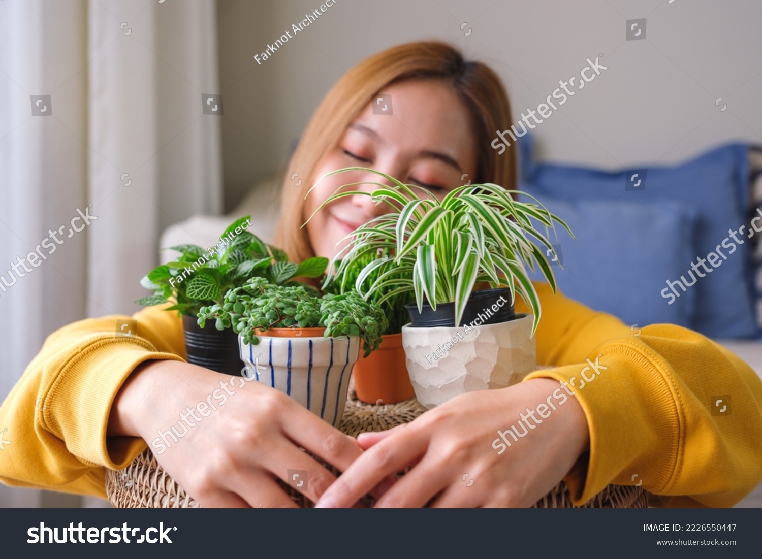 Portrait image of a beautiful young woman holding and hugging houseplants at home #2226550447