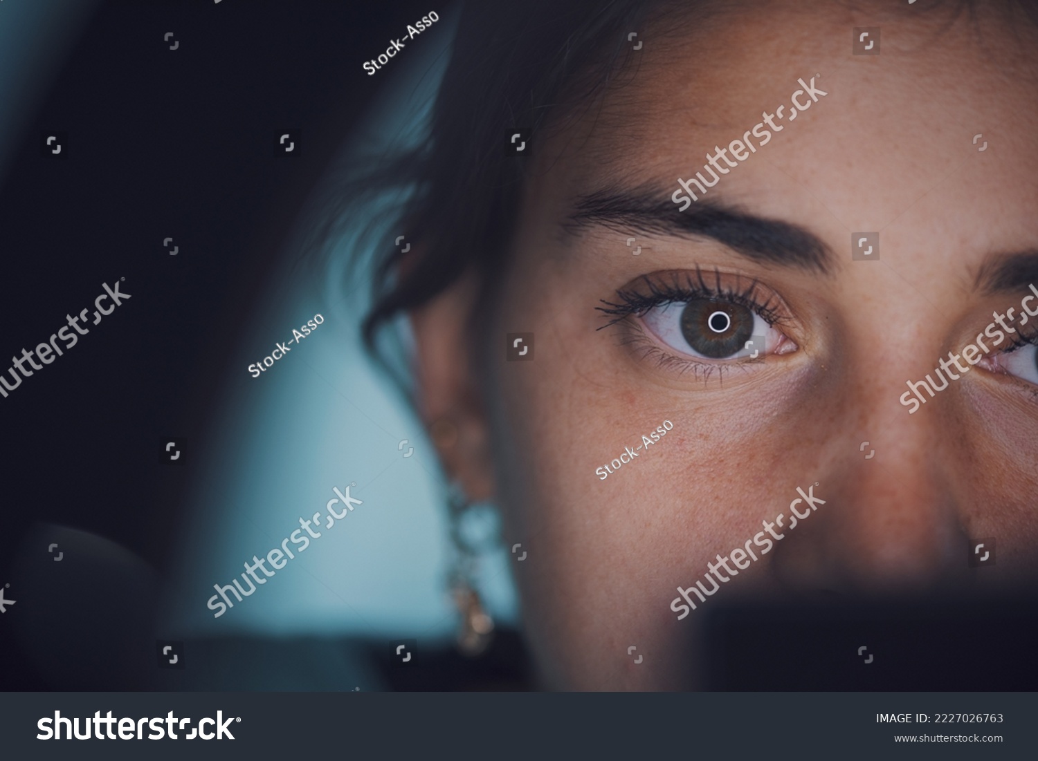 Ring light reflecting in woman's eye, face close up #2227026763