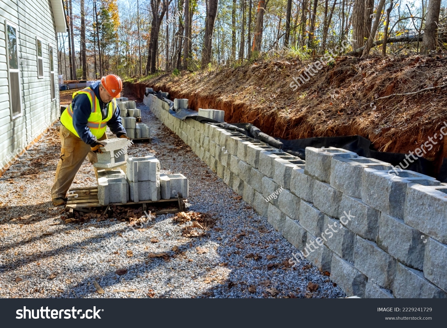 Contractor was seen installing concrete block wall that is being built on part new retaining wall construction project #2229241729
