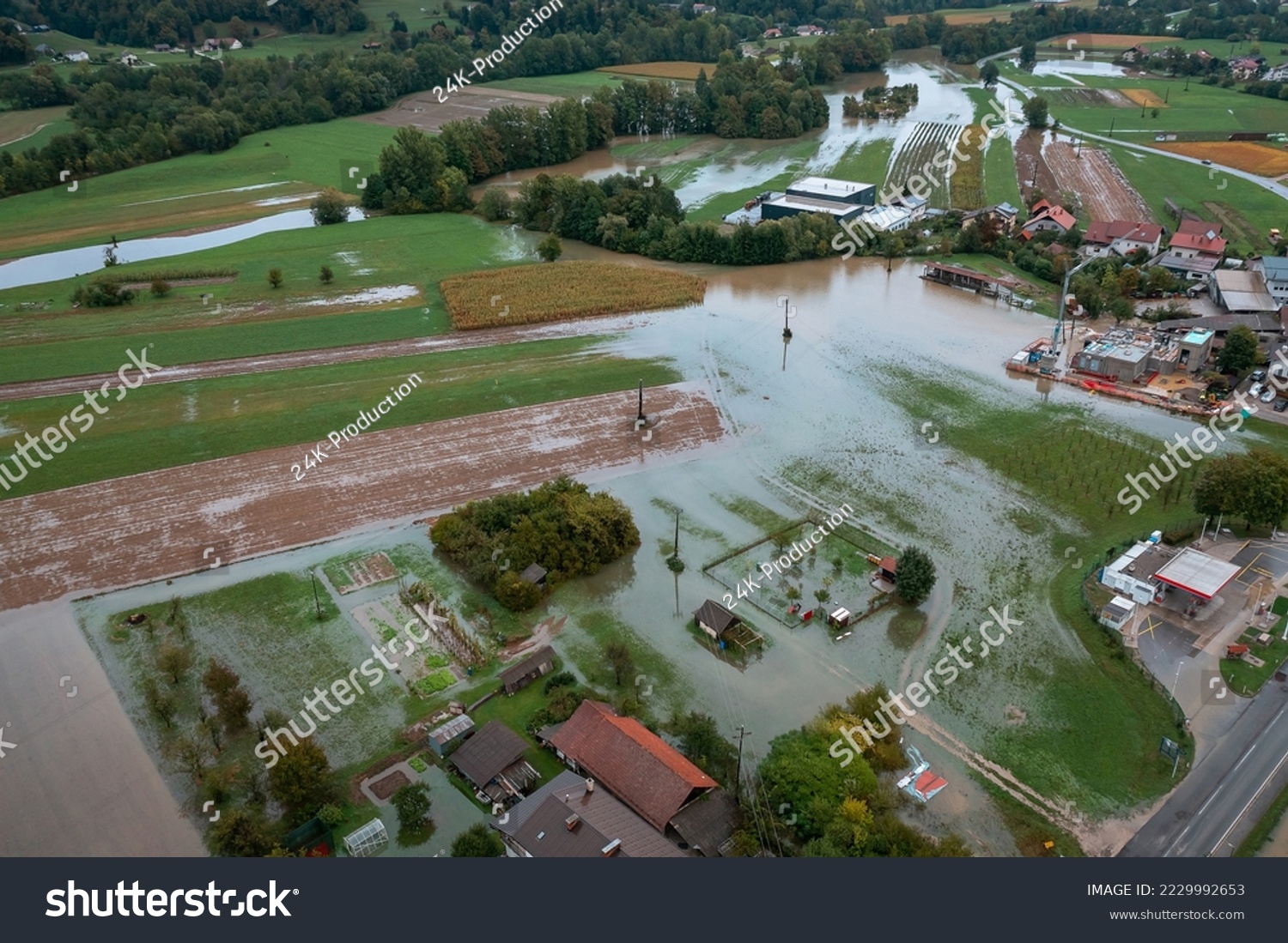 Extensive deluge across Europe, flooded mountain valley, near the households area and traffic ways, drone shot. Extreme climate event. #2229992653
