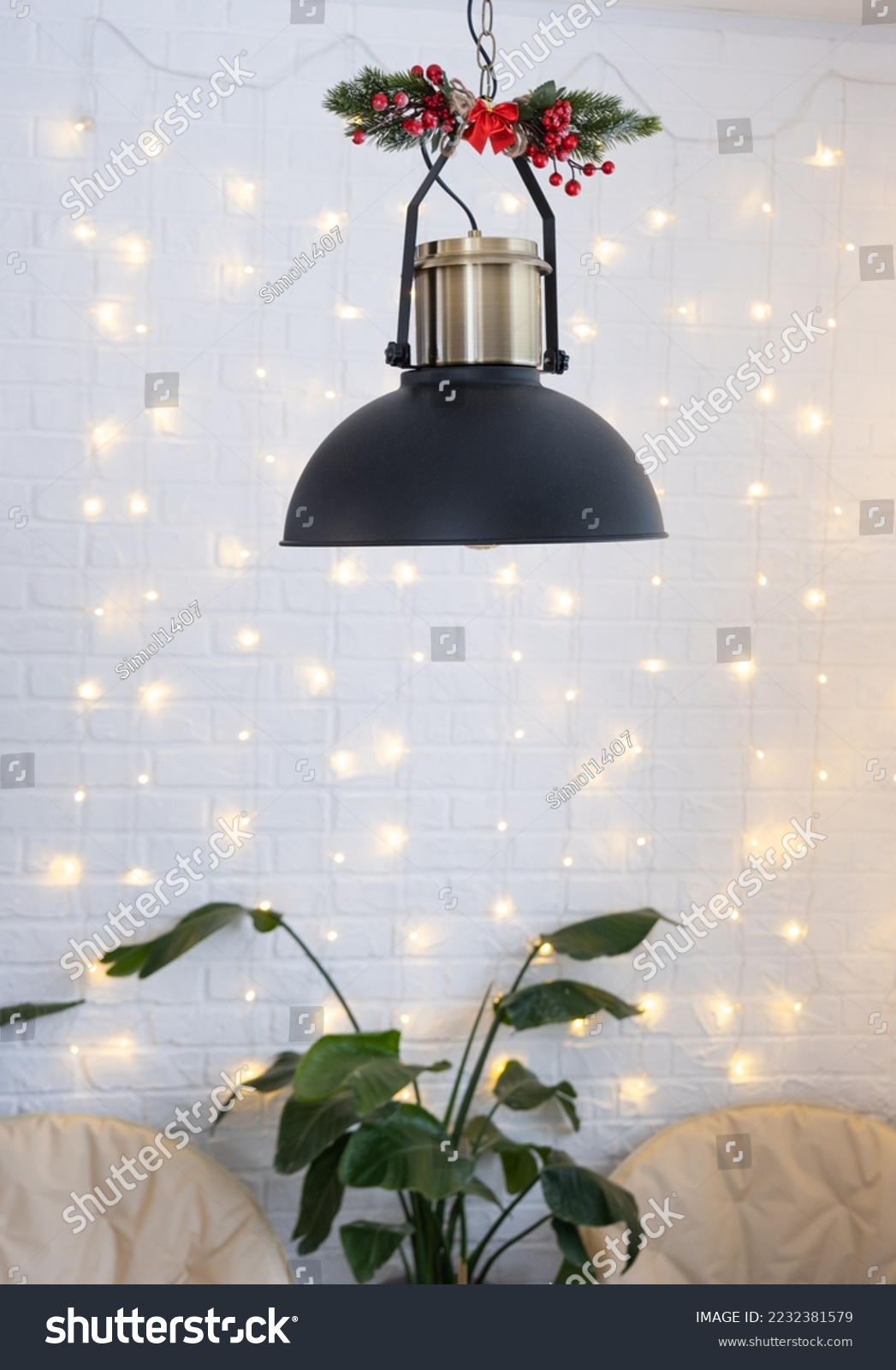 Christmas interior of a loft-style house with a black decorated retro lampshade and indoor plants of Strelitzia nicolai. New Year, comfort at home #2232381579