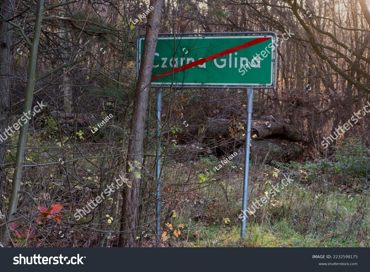 Table - a road sign meaning the end of the forest village. The middle of the forest in the peak of autumn on the periphery of a forest village " Czarna Glina " ("Black Clay").  #2232598175