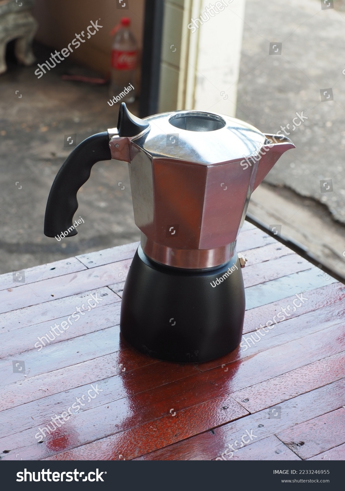 Small pressure coffee pot, Moka Pot, made of aluminum material, placed on a dark wooden floor table.  Ready to solve the stainless steel measure  The photo presents a shallow depth of field. #2233246955