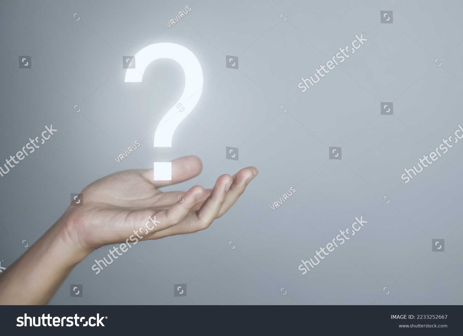 businessman's hand showing a question mark icon. The concept of alternatives. Confusion. Business solution. gray background. copy space #2233252667