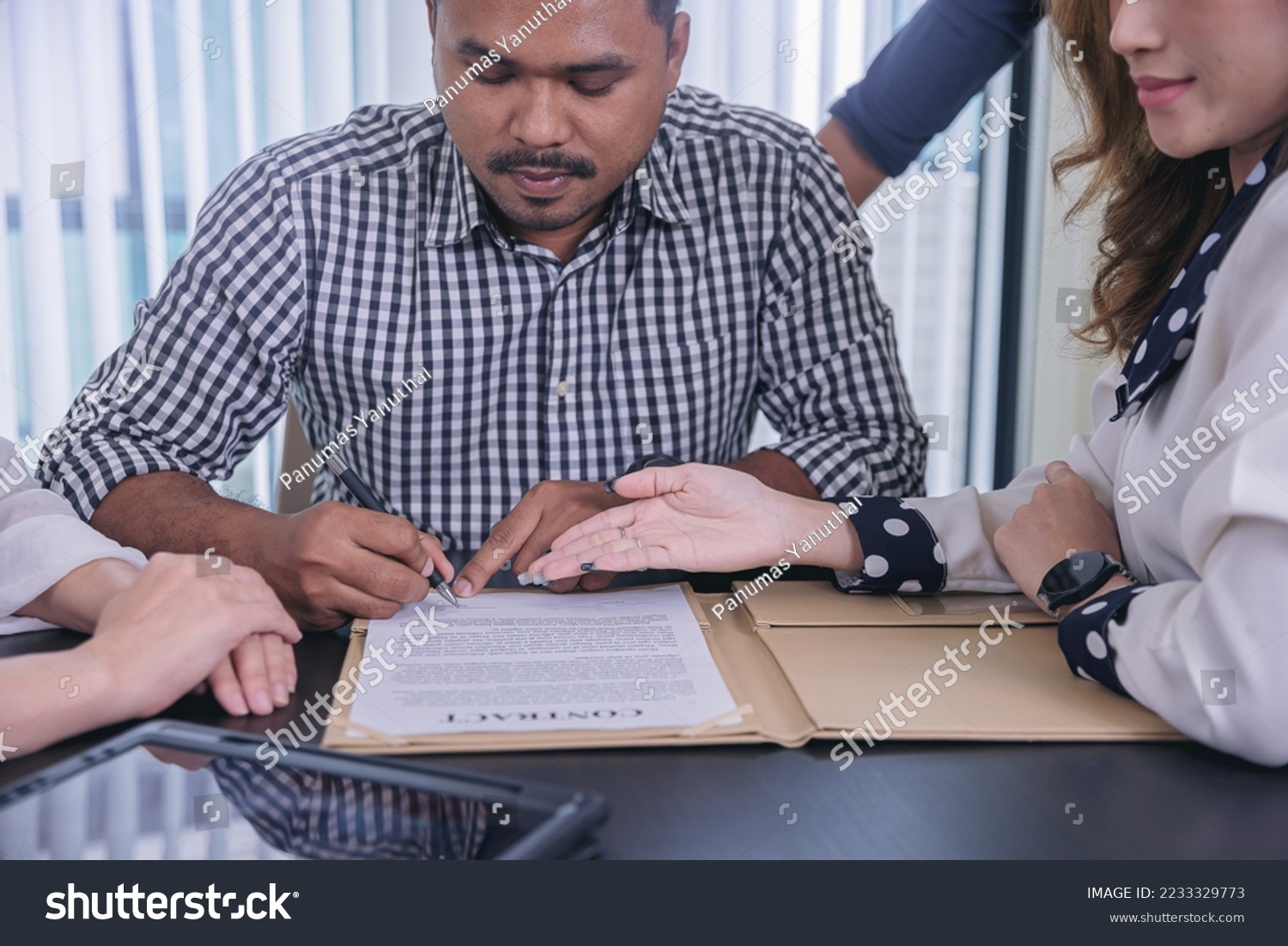 Businessman puts signature on contract at business meeting after negotiations with business partners. Selected focus #2233329773