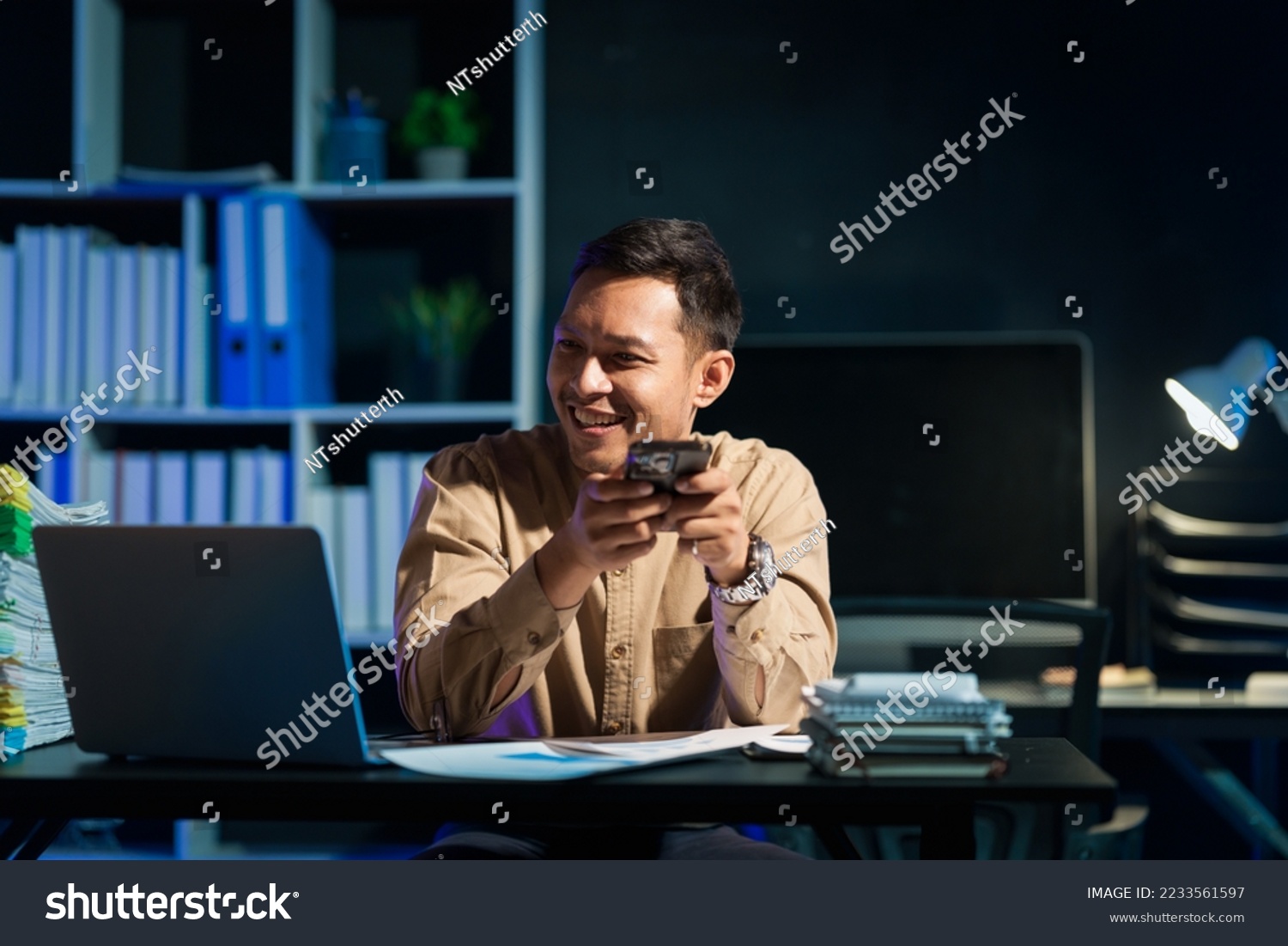 Overtime work concept, Handsome asian business man working late at night in office workplace. #2233561597