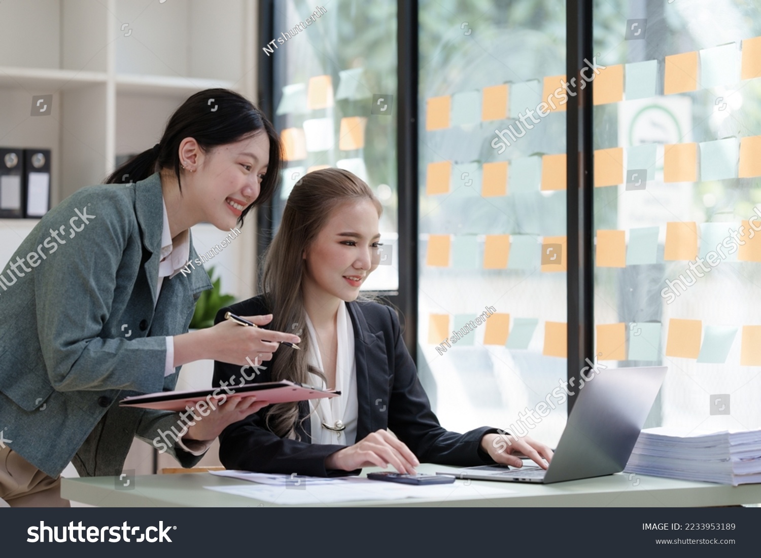 Female business worker with colleagues in Thailand working together at office desk, Female office worker business suit working with document file and paper work. #2233953189