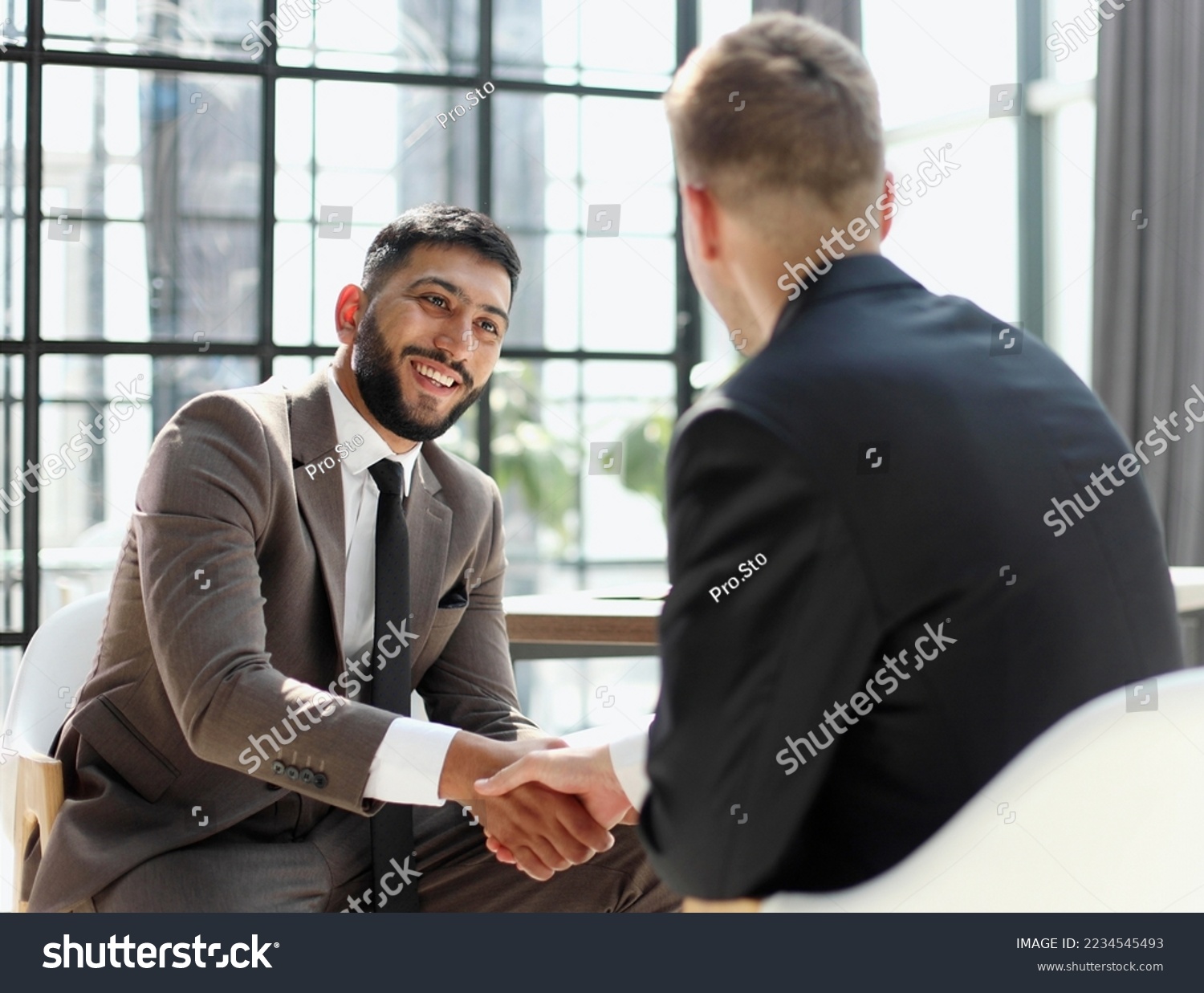 Business shaking hands, finishing up meeting. Successful businessmen handshaking after good deal. #2234545493