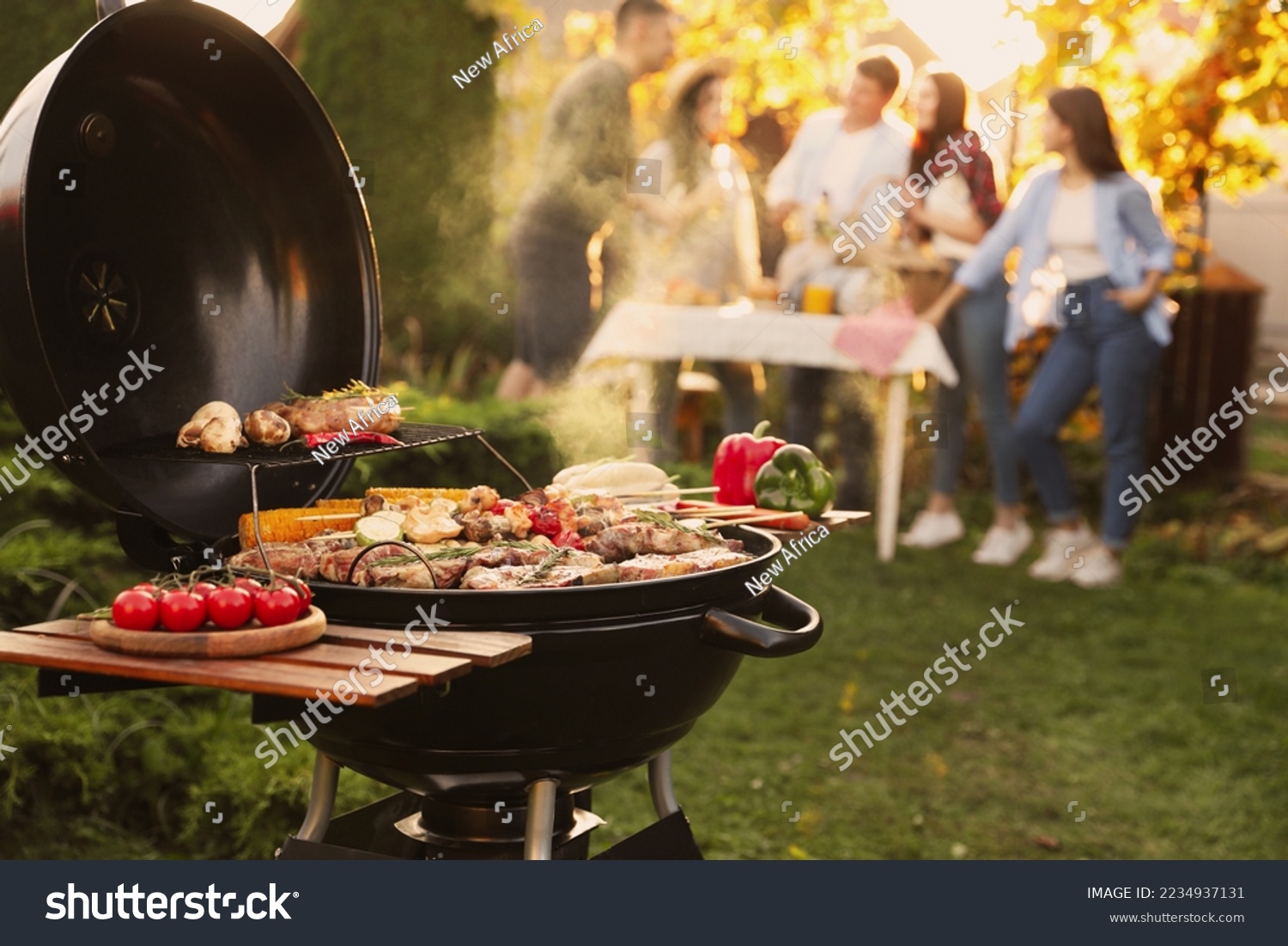 Group of friends having party outdoors. Focus on barbecue grill with food. Space for text #2234937131