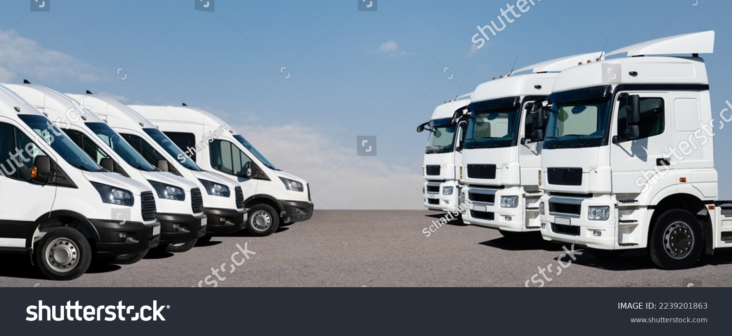 Semi trucks and delivery vans are parked in rows. Commercial fleet #2239201863
