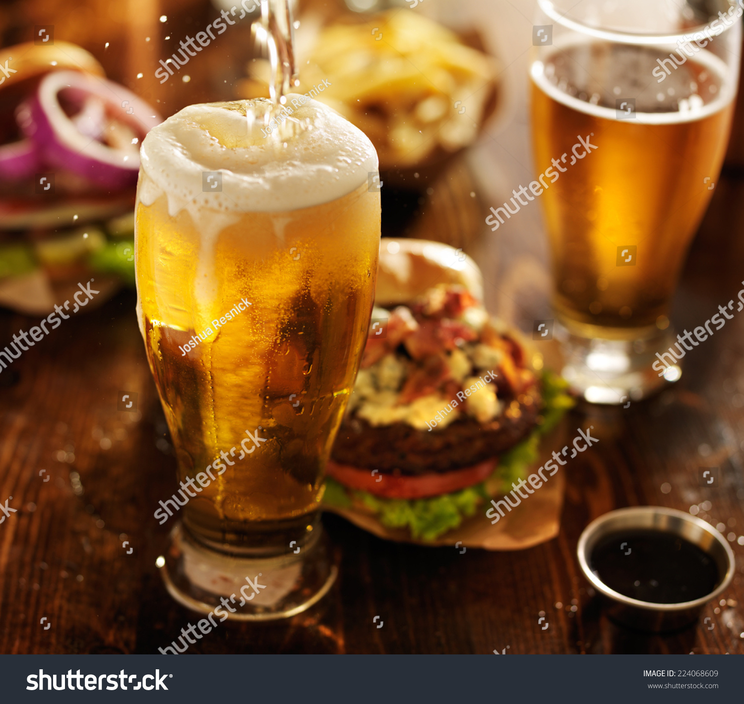 beer being poured into glass with gourmet hamburgers #224068609