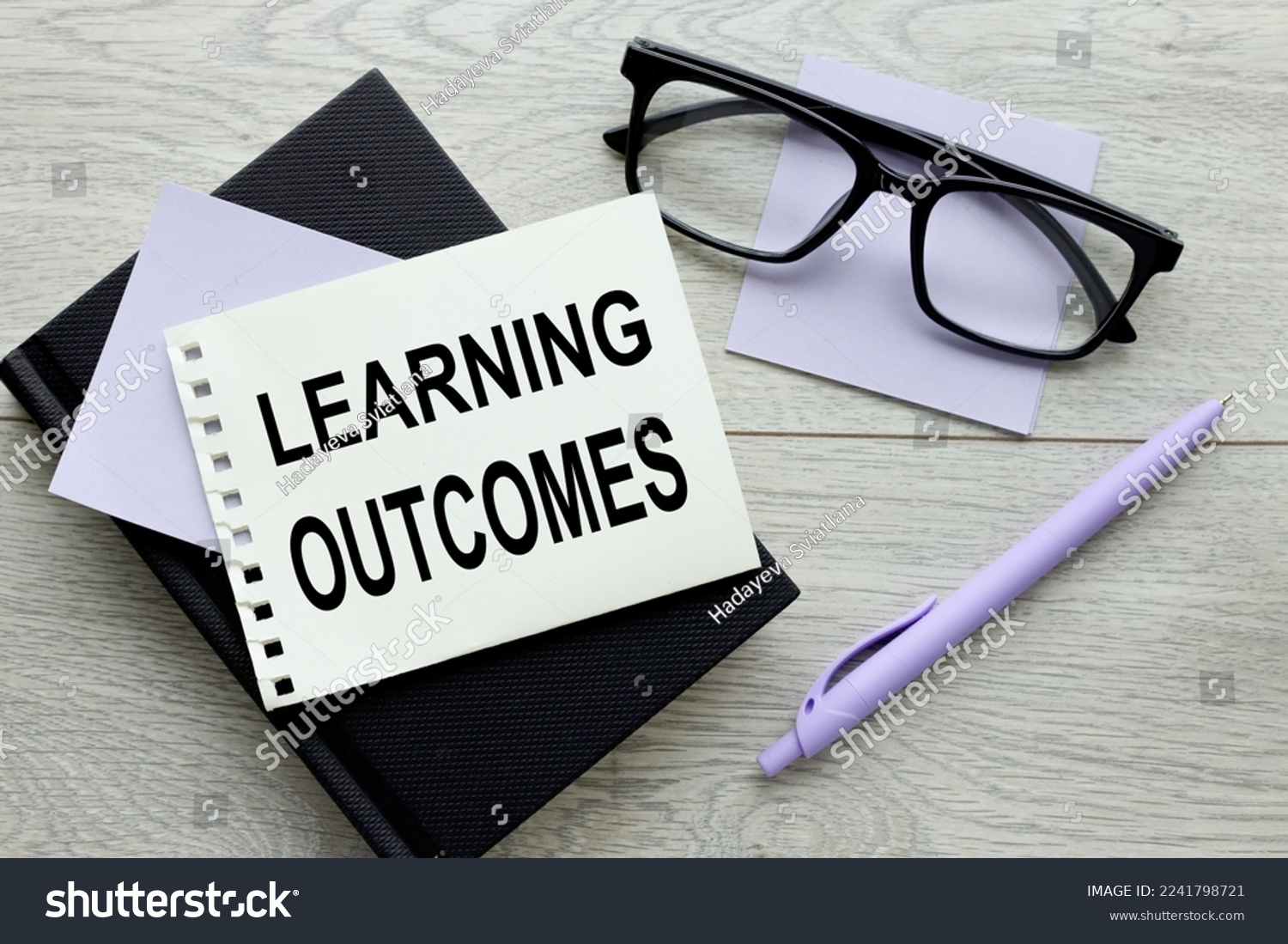 LEARNING OUTCOMES text on paper on wooden background. #2241798721