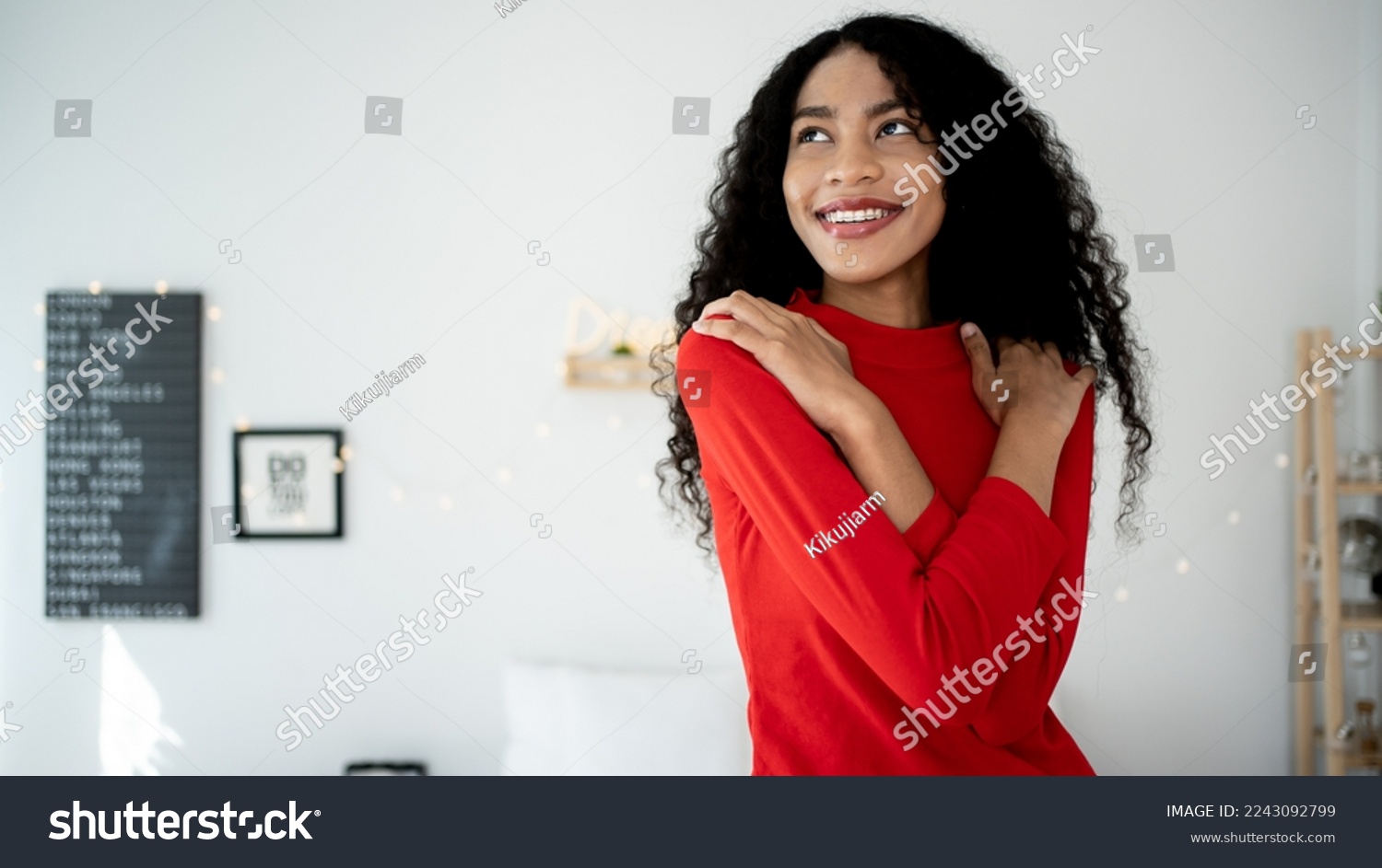 Embrace equity on multiracial Internal Women's Day. Lady African American good mood hands hug herself shoulders enjoy joyful red cloth laundry warmth toothy smile. #2243092799