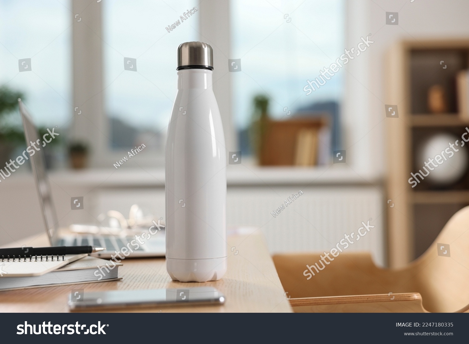 White thermos bottle at wooden table indoors #2247180335