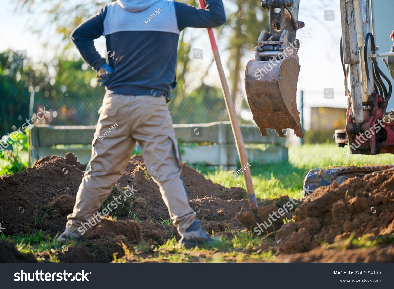 Construction worker in construction site.
Construction worker standing and watching bucket digger digging trench. #2247594159