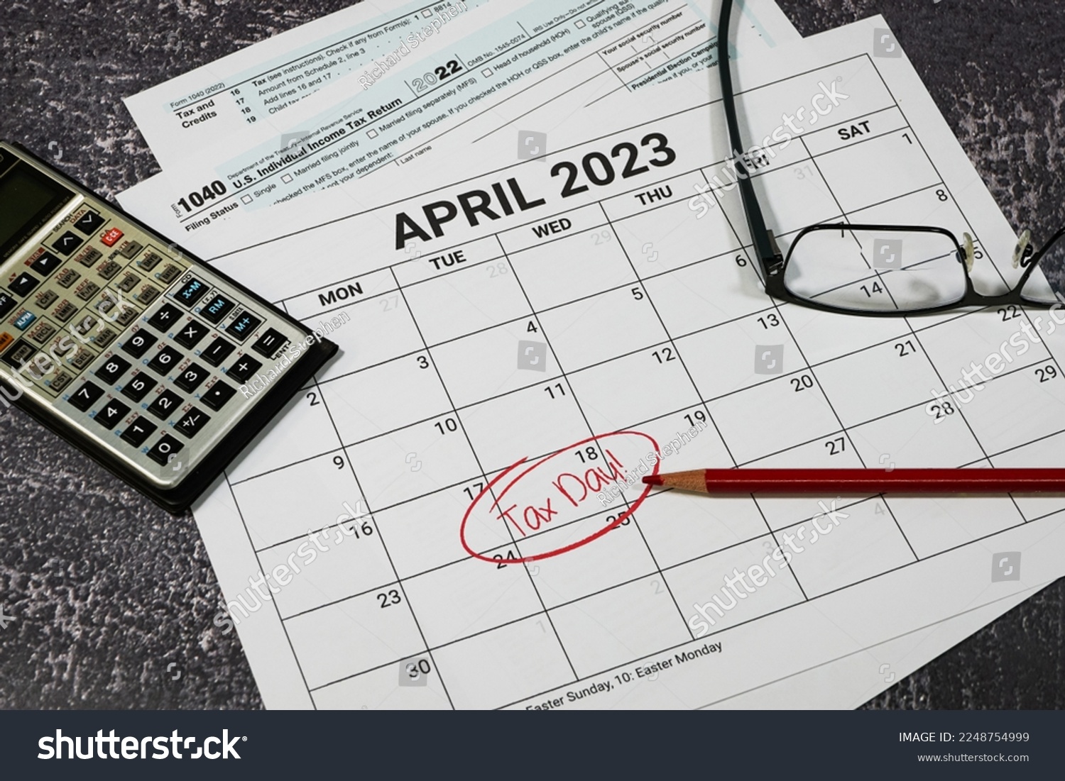 2023 US tax day calendar reminder with tax forms, calculator and glasses. #2248754999