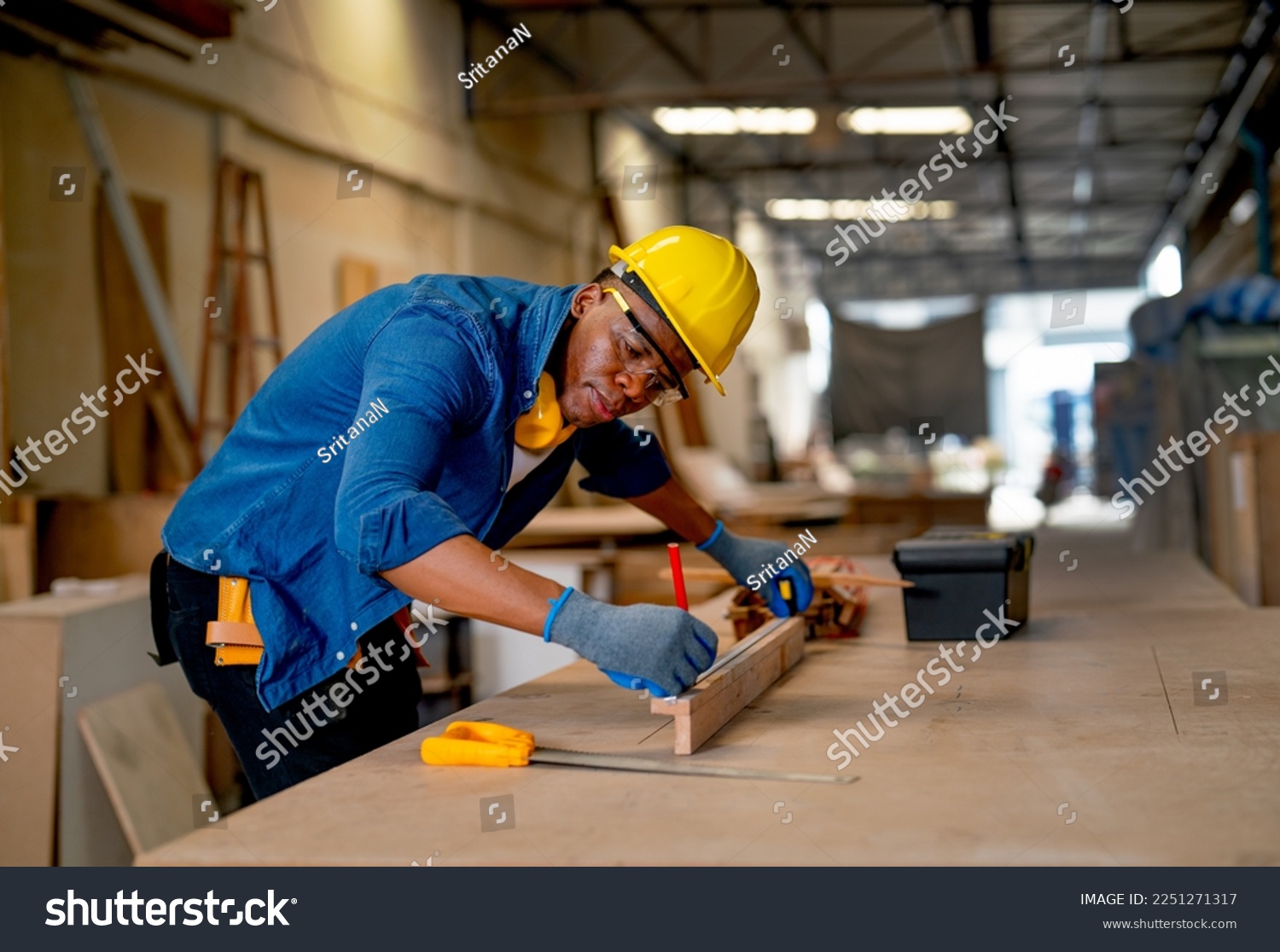 African American carpenter man use pencil to mark on timber during work with in wood factory workplace. #2251271317