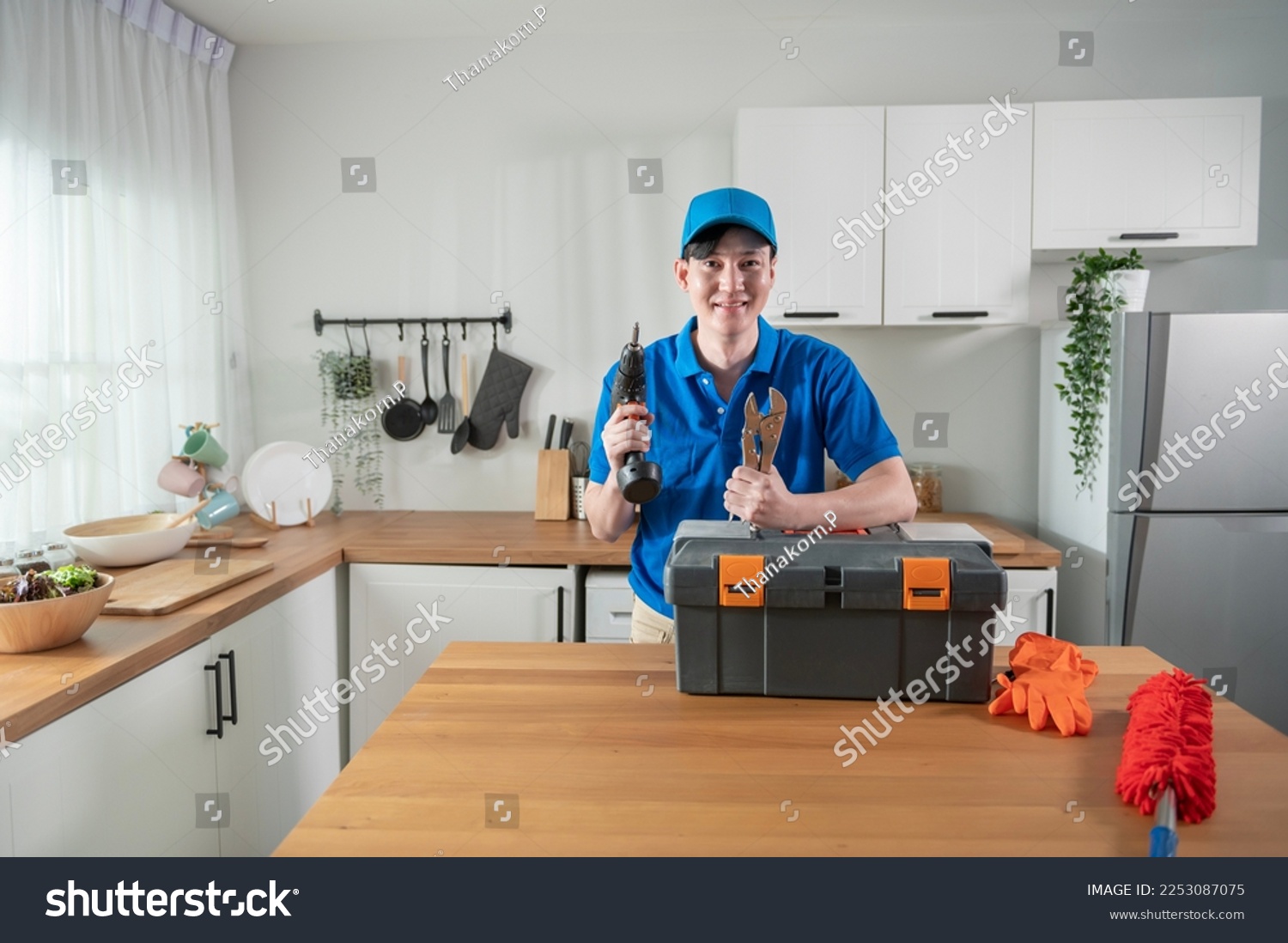 An Asian young Technician service man wearing blue uniform checking electrical appliances in home #2253087075