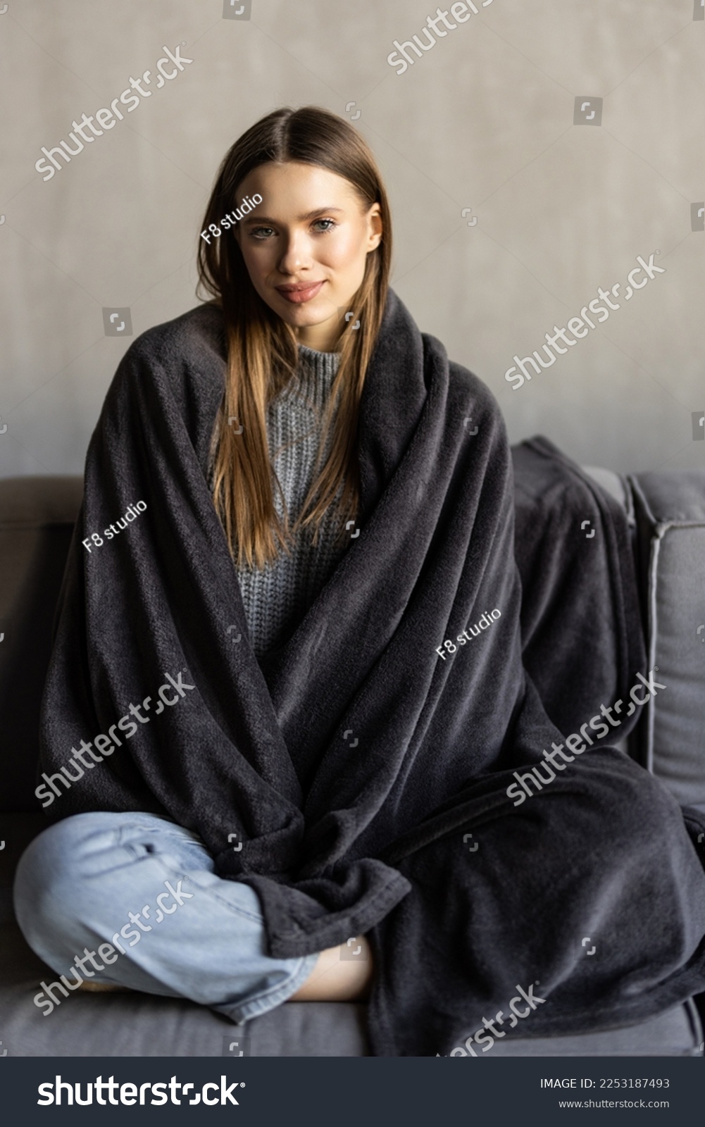 Young woman having a rest. Wrapped up in white blanket and drinking coffee in warm atmosphere, copy space #2253187493