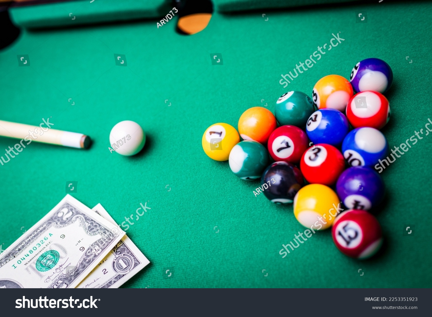 Gambling ardor game.Money and multicolored billiard balls with numbers.Dollar paper banknotes on the game table.Selective focus. #2253351923